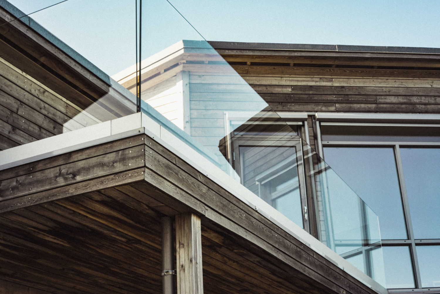 low angle shot modern wooden house with glass terrace borders